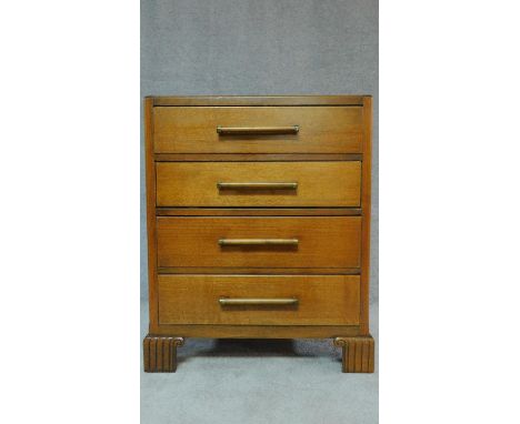 A mid 20th century Art Deco style oak chest of four long drawers on carved bracket feet. H.95 W.75 D.45cm 