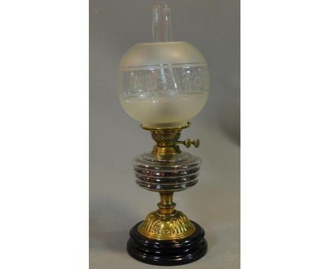 A late Victorian oil lamp with etched glass shade and brass base on turned ebonised socle. H.55cm 