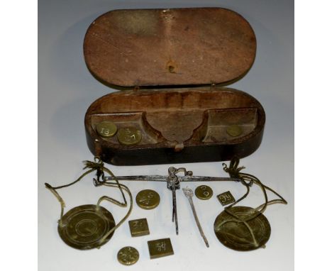 A set of George III brass and steel travelling balance scales, weights en suite, rounded rectangular mahogany case, 15cm wide