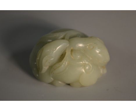 A Chinese pale celadon jade carving, of entwined rams, in the archaic taste, 5.5cm wide 