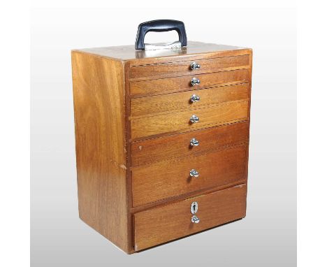 A mid 20th century teak dentist's cabinet, with seven drawers, containing assorted dentist's tools33w x 23d x 39h cm