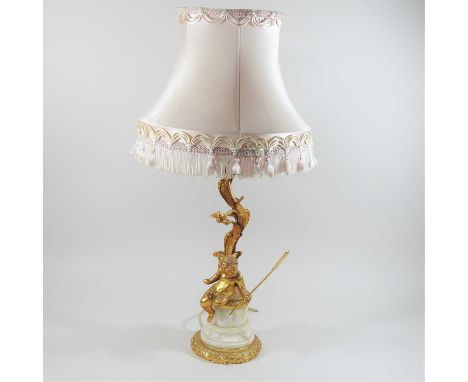 A gilt metal and marble figural table lamp and shade, decorated with a cherub perched on a socle base65cm high overall