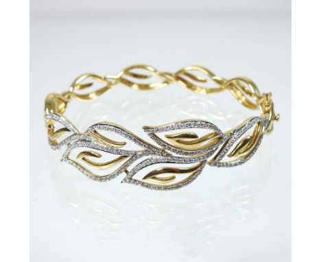 An 18 carat gold diamond set bangle, of foliate openwork design, 27g6.5cm diameter, 18mm wide