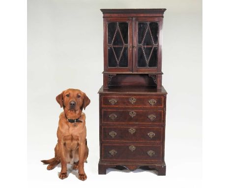 A George III mahogany children's bookcase over chest, having an astragal glazed upper section and containing four crossbanded