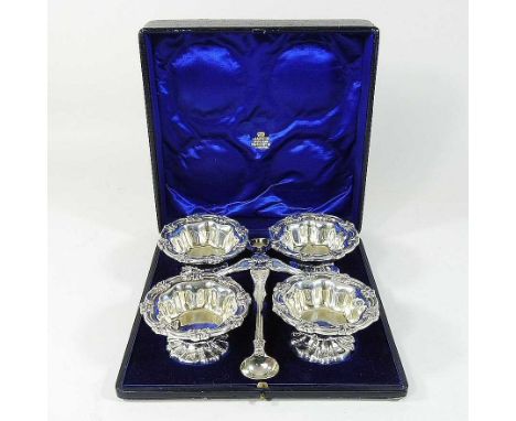 An early 20th century silver four piece condiment set, comprising four open pedestal bowls and four mustard spoons, London 19