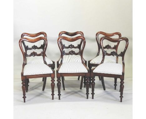 A set of six Victorian rosewood kidney back dining chairs, each having a carved horizontal splat and padded seat, on turned l