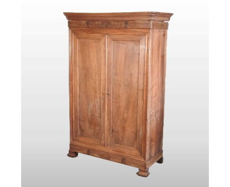 A 19th century French fruitwood armoire, of large proportions, with a moulded cornice and enclosed by a pair of panelled door