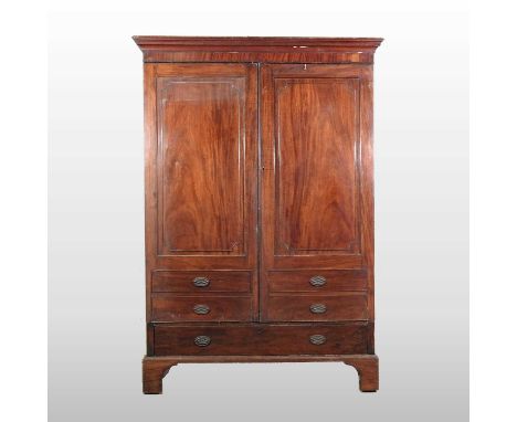 A George III mahogany double wardrobe, with a moulded cornice and enclosed by a pair of panelled doors, with dummy drawers be