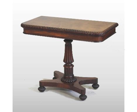 A Regency rosewood D shaped folding card table, the hinged top, with a turned edge, on a turned and fluted column and platfor