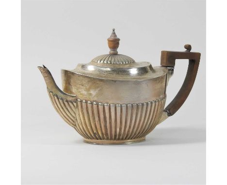 A Victorian silver teapot, of oval shape with a half gadrooned body and hinged lid, with a fruitwood handle and matching turn