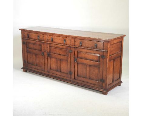 An 18th century style oak dresser base, late 20th century, containing three short drawers, over panelled doors198w x 54d x 86
