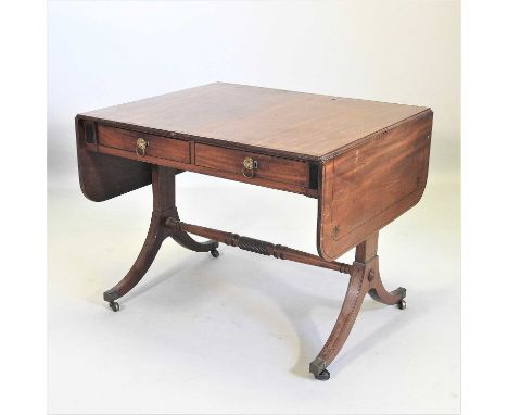 A Regency mahogany and ebony strung sofa table, with a hinged rectangular top, containing a pair of short frieze drawers, on 