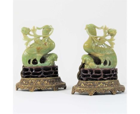A pair of Chinese jade coloured carved hardstone models of birds, each on a carved wooden and gilt base (2)16cm highCondition