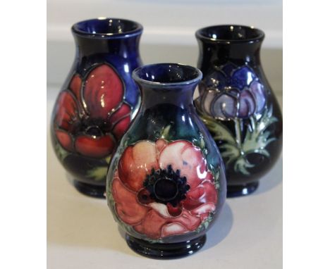 Three Moorcroft ceramic baluster vases, tube lined and painted floral designs on a cobalt blue ground, each with impressed an