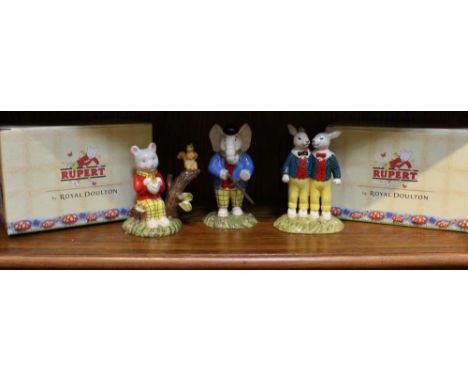 Three Royal Doulton "Rupert" ceramic figurines, two in original boxes together with "Pretending to be an outlaw" not boxed (3
