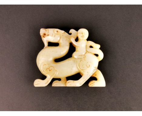 A Chinese 19th / 20th Century mutton fat and russet jade figure of a boy riding a dragon, H. 8.3cm, L. 10cm.