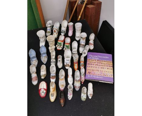 A group of approximately 30 19th and 20th Century mostly larger scale ceramic shoes together with pictoral souvenirs of Brita