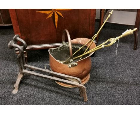 A pair of early cast iron andirons together with a copper coal bucket and brass fire tools.