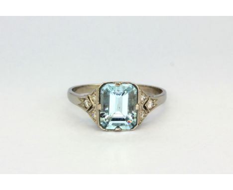 An Art Deco platinum (stamped Plat) ring set with an emerald cut aquamarine and diamond set shoulders, (P).