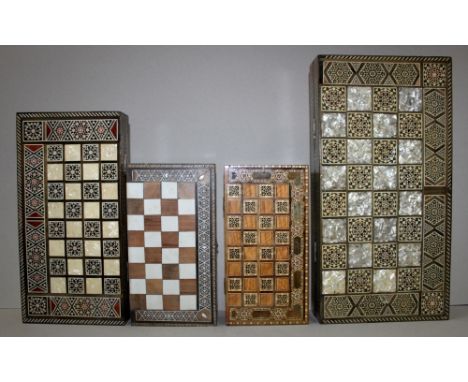 Asien. Vier klappbare Spielkisten aus Holz mit Intarsien mit Spielbrettern für Schach / Dame und Backgammon. Aus der Produkti