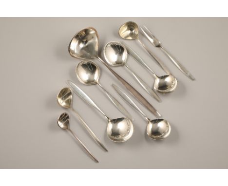 A suite of Georg Jensen silver servers, including a large ladle, pair of sauce ladles, a small ladle, large spoon, four servi
