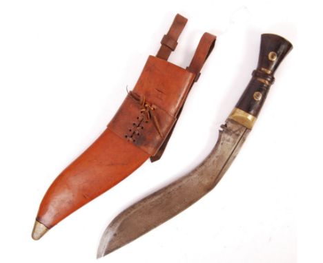 A WWI First World War style Gurkha Regiment Kukri Knife and scabbard. The knife having a shaped mahogany and brass handle wit