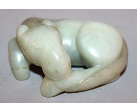 A CHINESE GREEN JADE LIKE MODEL OF A HORSE, modelled lying down, the details engraved, 2.8in long. 