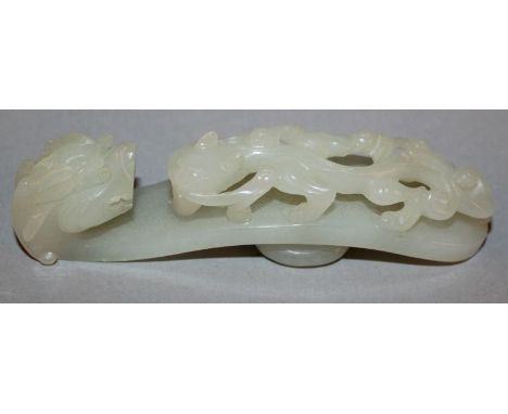 A GOOD QUALITY CHINESE CELADON JADE BELT HOOK, the hook formed from a dragon’s head, the stem carved with a sinuous chilong i