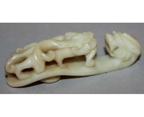 A SMALL CHINESE JADE BELT HOOK, the hook formed from a dragon’s head, the stem carved with a sinuous chilong in pierced relie