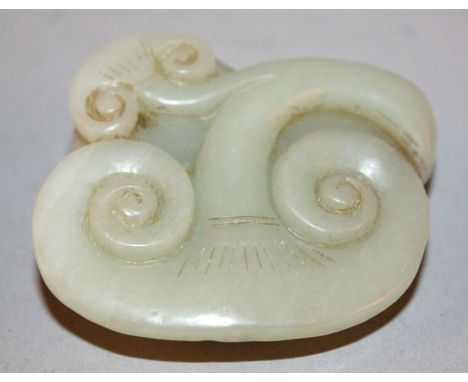 A CHINESE CELADON GREEN JADE CARVING OF A BUDDHISTIC LION, depicted lying on a spray of lingzhi, 2.25in wide. 