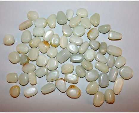 A QUANTITY OF APPROX 65 CHINESE JADE BEADS, variously pebble shaped, of celadon green tone, some with russet inclusions, aver