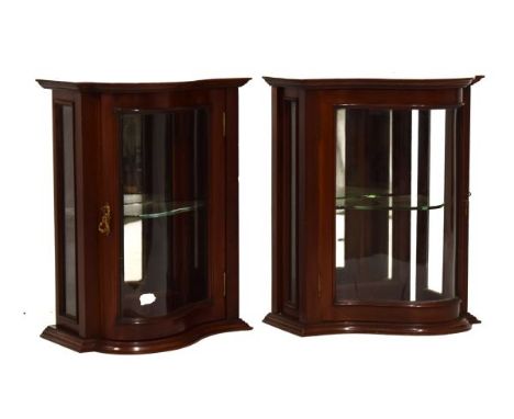 Pair of early 20th Century serpentine-fronted mahogany display cabinets with glazed curved hinged front door between plain gl