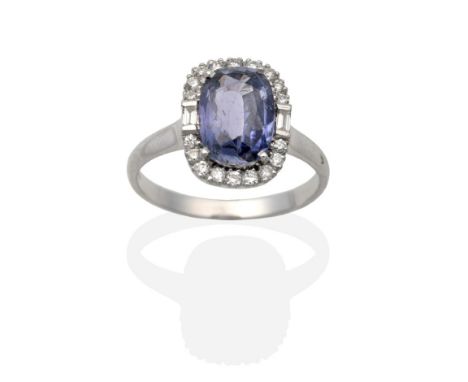 An 18 Carat White Gold Synthetic Colour Change Sapphire and Diamond Cluster Ring, an oval cut sapphire in a claw setting, wit