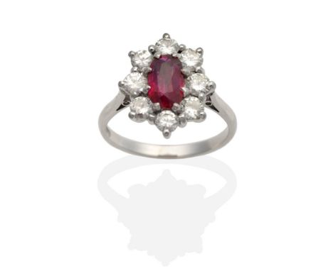 A Ruby and Diamond Cluster Ring, an oval cut ruby in a claw setting, within a border of round brilliant cut diamonds, to knif