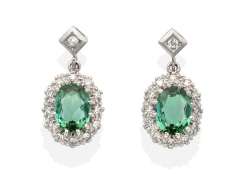 A Pair of Green Tourmaline and Diamond Cluster Earrings, an eight-cut diamond in a square setting suspends an oval cut green 