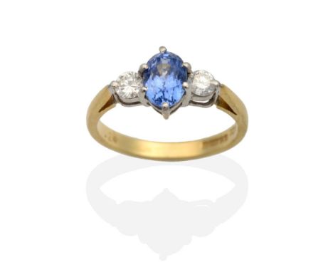 An 18 Carat Gold Sapphire and Diamond Three Stone Ring, an oval cut sapphire in a claw setting, spaced by round brilliant cut