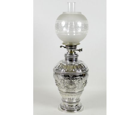 A large and impressive 19th century silver paraffin lamp, of ovoid form with all over repousse decoration, green man masks, g