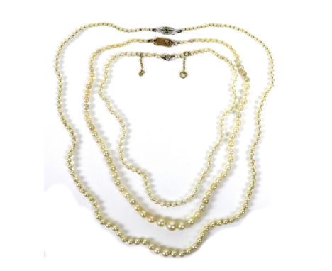 A group of three pearl necklaces, the first a with diamond solitaire clasp of approximately 0.15ct, each pearl approximately 