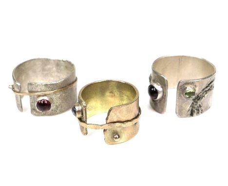 A group of three modern design rings by Bek Genery, all of open design, one gold, unmarked and untested, with moving band det