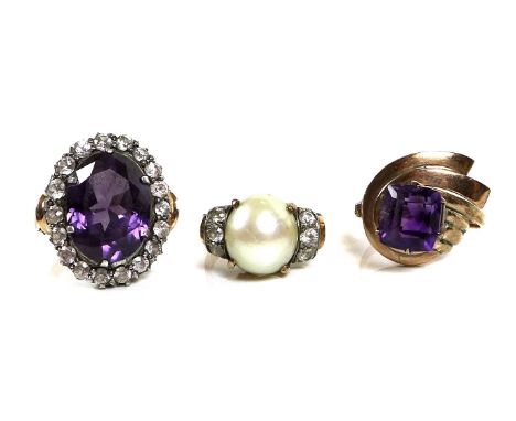 A group of three rose gold dress rings, the first 14ct set with a large oval amethyst surrounded by paste stones, size M, 5.8