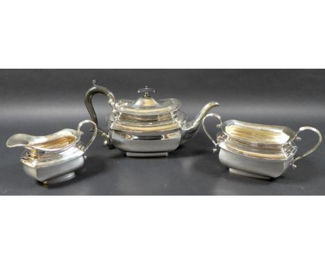 An Edward VII silver three piece tea service, of London shape, comprising teapot with ebonised wooden finial and handle, 28 b