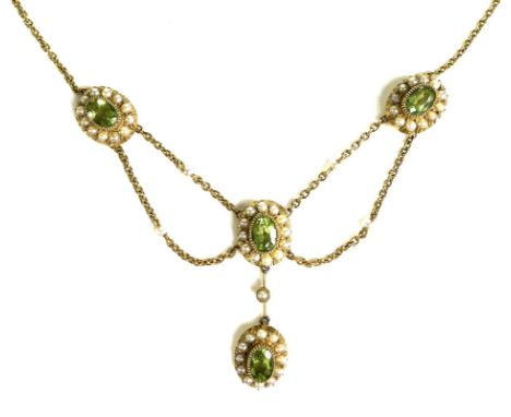An Edwardian 15ct gold, seed pearl and green stone festoon necklace, each stone approximately 6 by 4mm, 9.2g, 42cm long. 