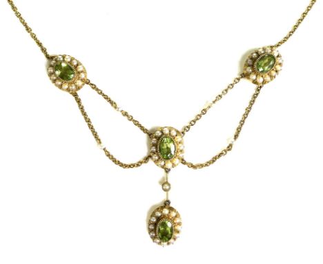 An Edwardian 15ct gold, seed pearl and green stone festoon necklace, each stone approximately 6 by 4mm, 9.2g, 42cm long. 