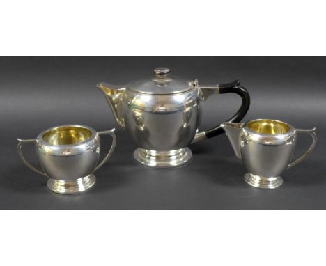 An Art Deco Indian Colonial silver three piece tea set, by Warner Bros, comprising teapot with ebonised wooden handle and fin