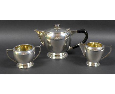 An Art Deco Indian Colonial silver three piece tea set, by Warner Bros, comprising teapot with ebonised wooden handle and fin