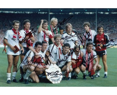 Autographed MAN UNITED 1983 ; Col photo measuring 12 x 8 depicting Man United players celebrating with the Charity Shield in 