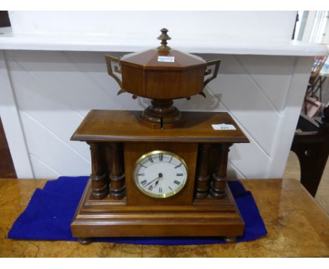 An Edwardian walnut cased Mantel Clock, of columned architectural form, the case surmounted by a two-handled cup with hinged 