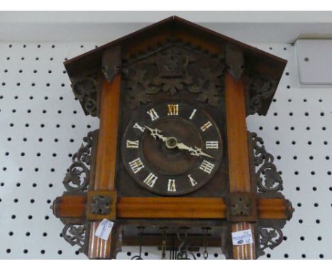 An early 20th century Black Forest Cuckoo Clock, with pendulum and two weights, the case 12½in (32cm) high x 11in (28cm) wide