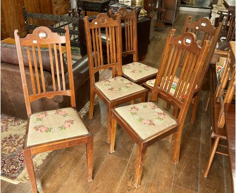 A set of five Arts and Crafts walnut Dining Chairs, each with central circular detailing to top rail, raised on stick back, a