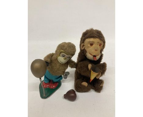 A VINTAGE TINPLATE WIND UP BOXING MONKEY TOGETHER WITH A FURTHER TINPLATE MONKEY HOLDING A CONE 